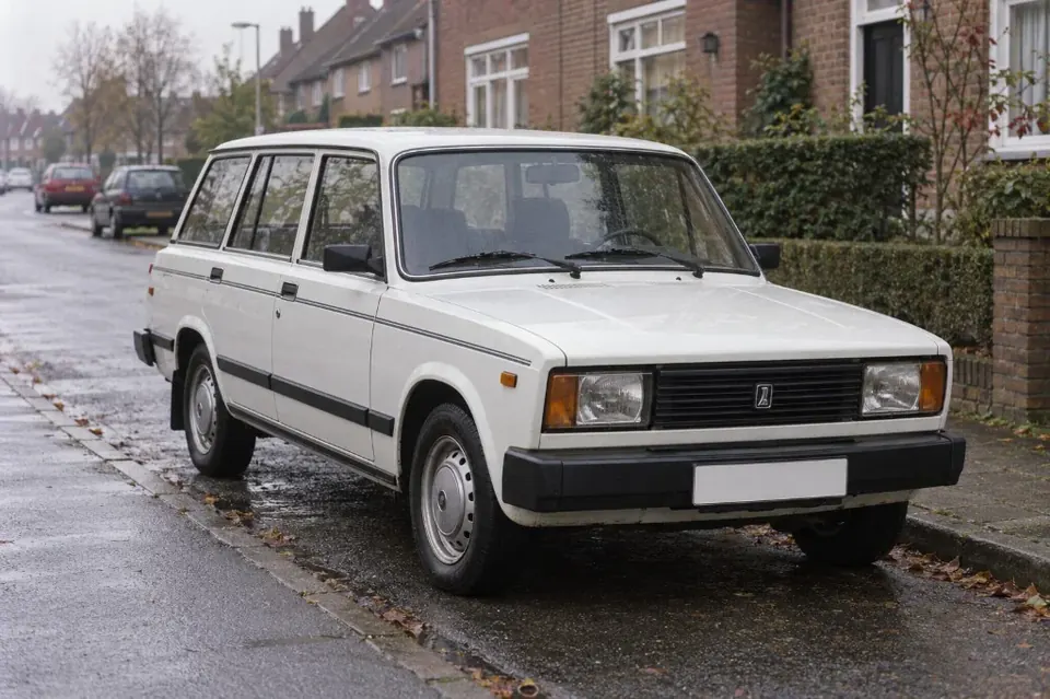 Белый универсал Lada 2104 с тонкой полосой на боку припаркован на тихой европейской улице